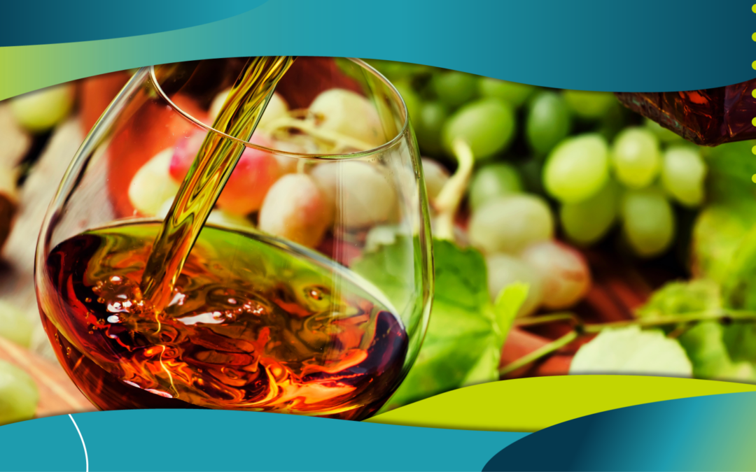 A photo of cognac being poured into a glass, set against a graphic background with green and blue curves. The image captures the amber liquid in clear detail as it flows from a decanter, with green grapes and leaves softly blurred in the background, enhancing the focus on the drink